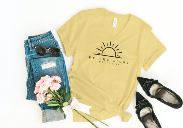 Flat lay of yellow t-shirt, jeans, and some accessories